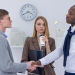 Two diverse business professionals shaking hands, symbolizing partnership and collaboration.